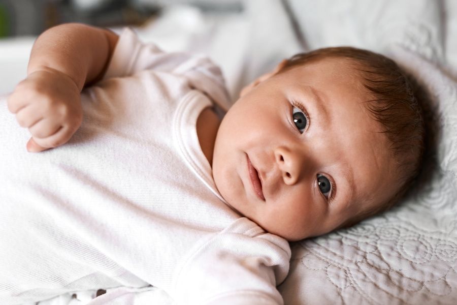 Emily Clark closely observing a baby during a tongue-tie assessment